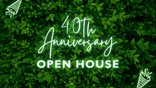 40th Anniversary Open House written in neon letters in front of a greenery wall with neon party poppers in the corners