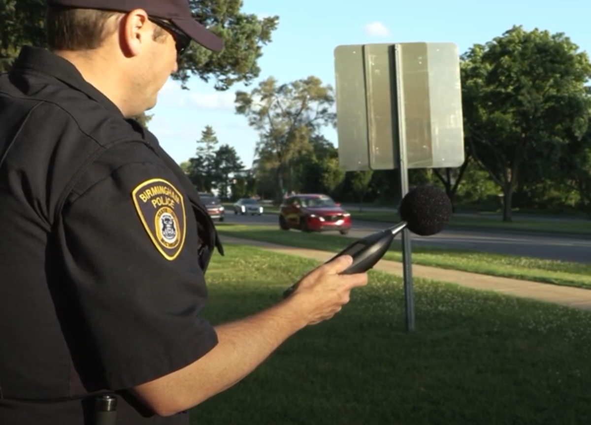 Birmingham police officer holding a microphone out to traffic. 