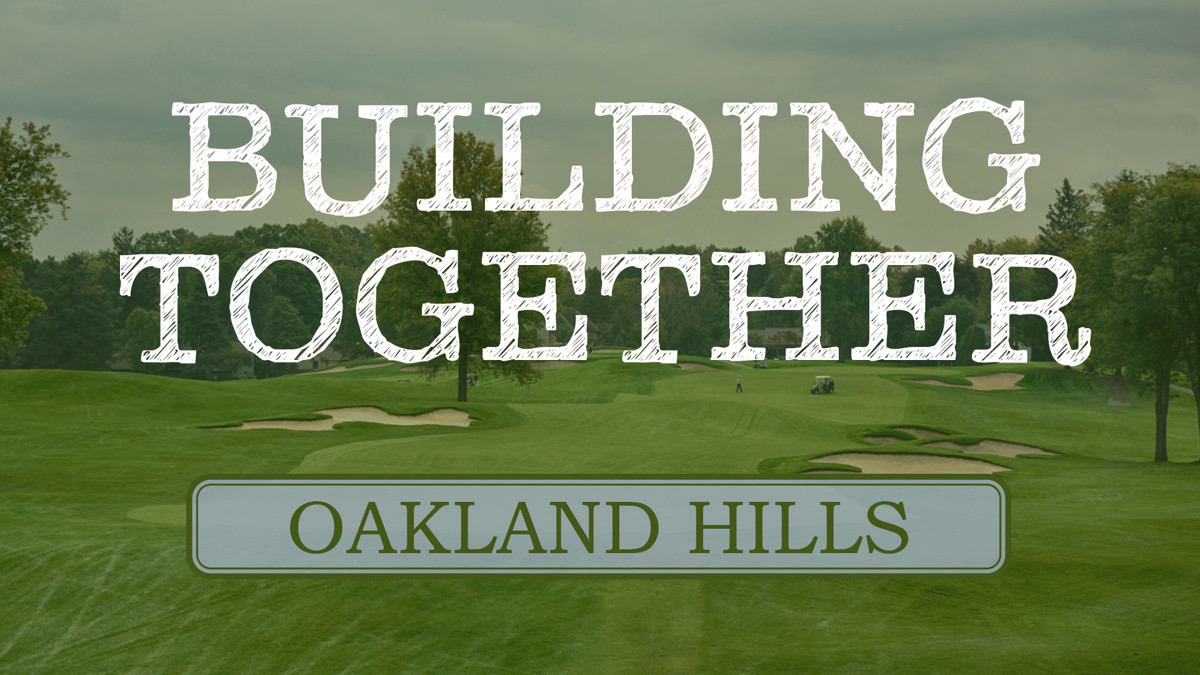 A golf course with the words "building together Oakland Hills" in front of it. 