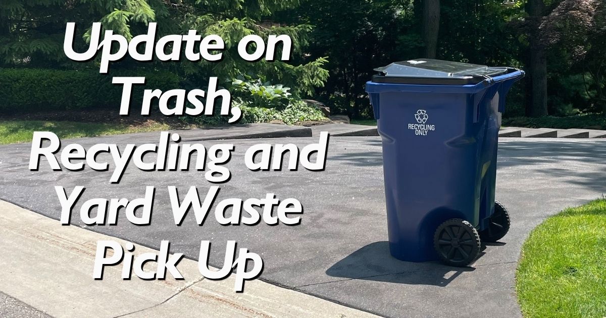 A blue recycling cart at the end of someone's driveway with message: Update on Trash, Recycling and Yard Waste Pick Up