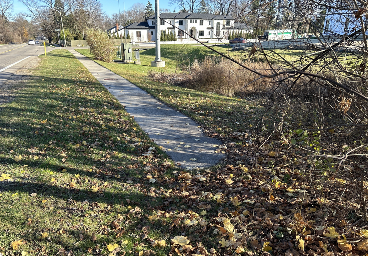 A section of sidewalk along a main road that appears to end.
