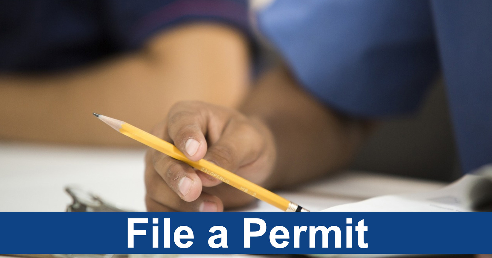 A hand holding a pencil to paper with the words "file a permit" underneath it.