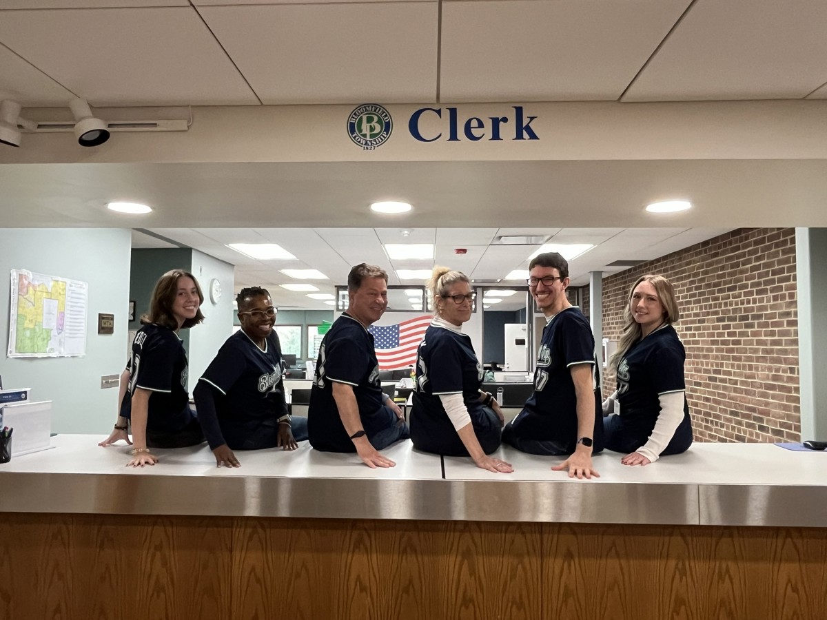 Clerk's Office staff sitting on counter facing away from camera but heads turned towards camera.