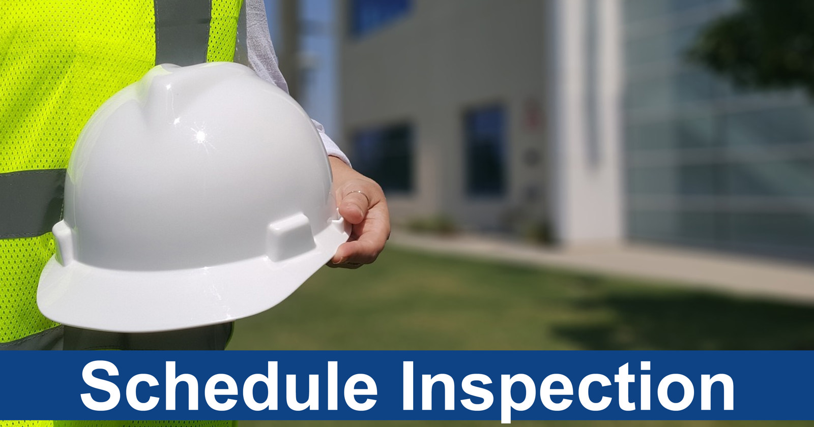 A person dressed in a safety vest holding a hard hat with the words "schedule inspection" underneath it.